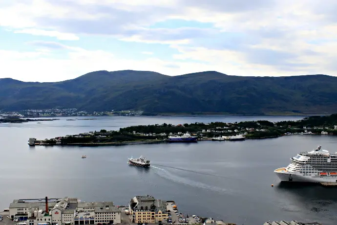 A cruise ship in the water near a city
